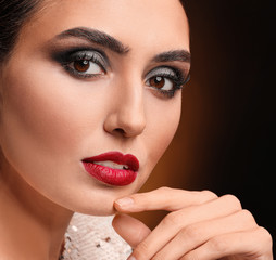 Young woman with beautiful makeup on dark background