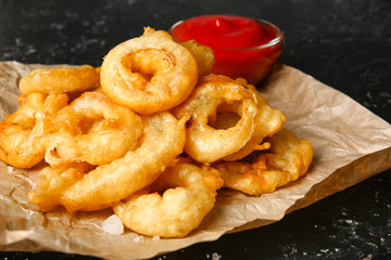Crispy fried onion rings and sauce on table