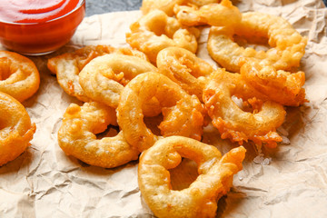 Crispy fried onion rings on table
