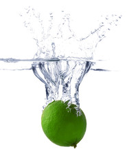 Falling of fresh lime into water against white background