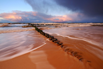 Morze Bałtyckie,falochron na piaszczystej plaży w Kołobrzegu.