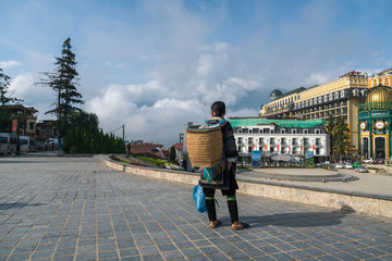 Ethnic minority Hmong woman with wooden basket on back in beautiful costume dress in Sapa, Vietnam