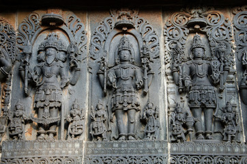 Carved idols on the outer wall of Hoysaleswara temple, is a 12th-century Hindu temple dedicated to...