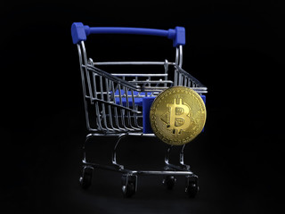 Shopping cart with gold bitcoin on the front isolated on black background