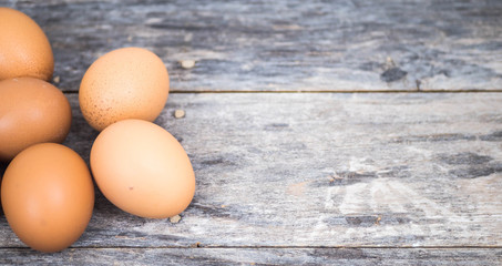 The chicken eggs are laid on the left side in groups on the old wood, with free space on the right side.