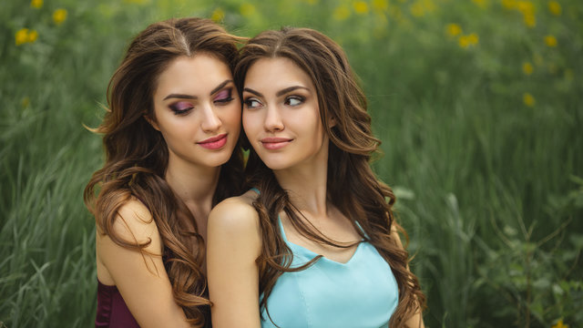 Fashion Portrait Photo of Two Women Against Green Grass Meadow on Nature