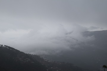 view of green mountain in rainy season with fog and clouds covering its peaks