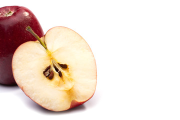 half of a ripe red Apple next to a whole close-up on a white isolated background