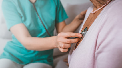Cropped shot of caregiver use stethoscope to checking elderly woman heart beat