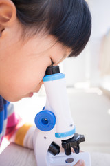 顕微鏡で自然観察をしている子供