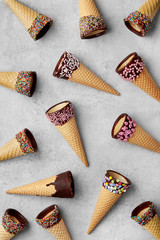 Ice cream cones pattern with chocolate sprinkles on a grey background viewed from above. Top view