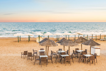 empty terrace bar on the sand of the beach by the sea at sunset. Guardamar, Alicante. Spain