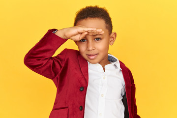 Keen eyesight and vision concept. Horizontal shot of sharp eyed curious dark skinned little boy...