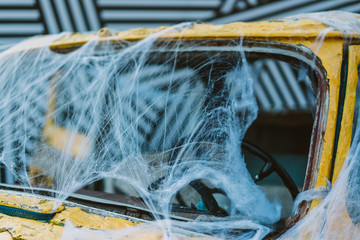 Old retro yellow taxi decorated with cobwebs