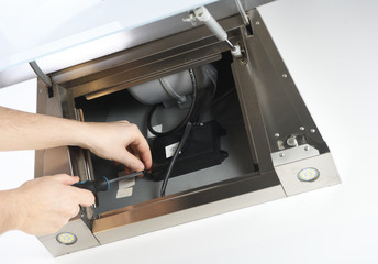 Male hands of an electrician troubleshoot a cooker hood.Cooker hood repair.