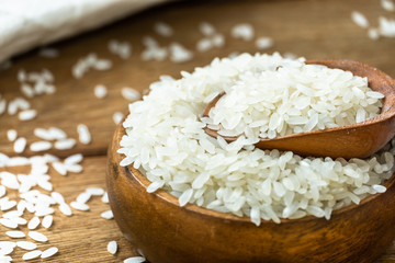 rice grains in bowl on wooden background