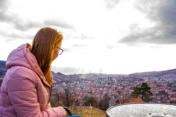 Woman sitting and drinking coffe above Sarajevo