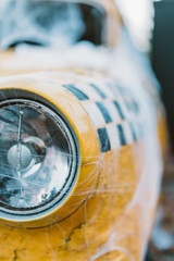 Old retro yellow taxi decorated with cobwebs