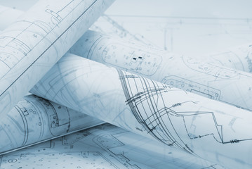 Rolled architectural plans lying on drawing board