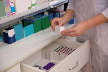 Professional pharmacist with medicine in drugstore, closeup