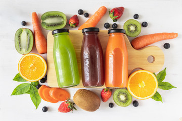 Set of homemade fresh fruit juice, natural source of vitamin C and supplement, healthy drinks in a glass bottle faly lay on white wooden background