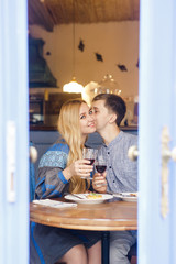 couple in blue clothes having dinner at a restaurant near the blue doors with a view of the city