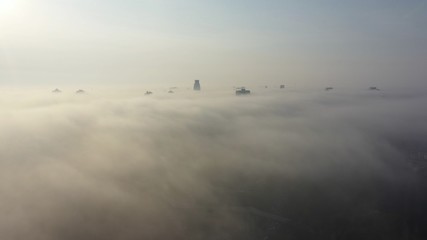 Aerial view of the city in the fog. Skyscrapers above the fog