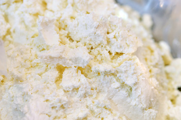 Crumbly cottage cheese on a store counter.