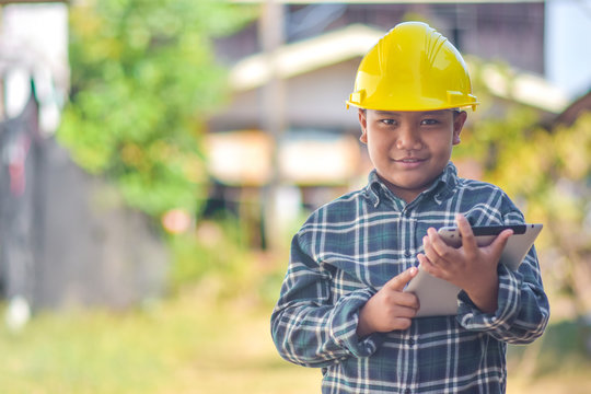 Boy kid hold tablet use hard hat engineer construction