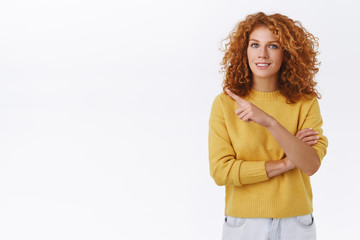 Girl pointing at product asking if you already check it out. Gorgeous smiling redhead woman with curly hair, showing you promo left side copy space, curious about advertisement, white background