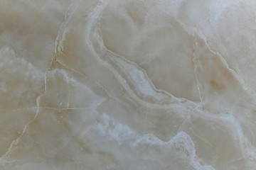  Natural beige polished marble with diagonal wavy lines.