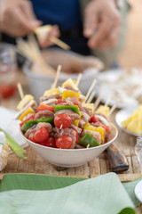 picnic and camping in forest, male prepare barbecue meat with barbecue skewers, cooking time