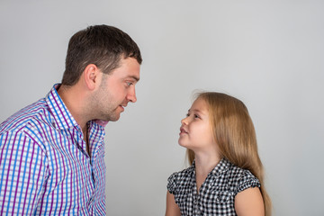 The dad and daughter  emotionally talking about something while looking at each other.