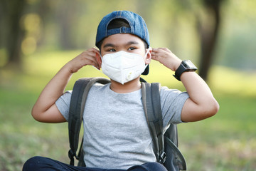 Naklejka premium A young Asian boy , 7 Years Old , wear mask to protect against dust PM 2.5 and germs