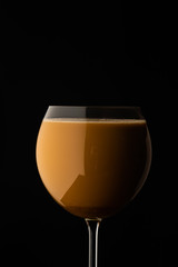  coffee with milk in a wine glass on a black background