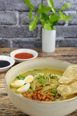 Bubur Ayam, Indonesian rice congee with shredded chicken, scallion, celery, fried soybean, boiled quail egg, yellow chicken broth and kerupuk