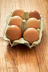 organic eggs in carton on a  wooden table