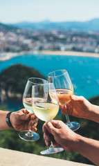 glasses white wine in friends hands outdoor seascape holidays, romantic couple toast with alcohol, people enjoying travel time together