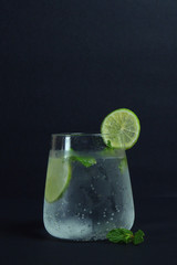 Cold ice lemon soda drink in glass black background