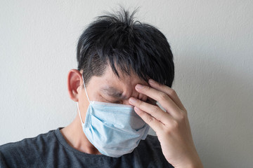 The Face of Sick Asian Chinese Man Wearing Face Mask feeling sick headache and  cough because of  Coronavirus Covid-19  Isolate on White Background