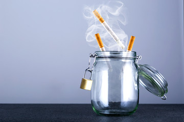 Flying cigarettes burning in box with copy space. Stop smoking.