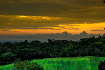 abstract background blur view of the sun shining through the clouds,surrounded by large mountains and various species of trees