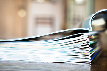 Closeup background of a pile of old magazines with bending pages