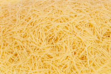 Raw vermicelli pasta (italian pasta) background, close up