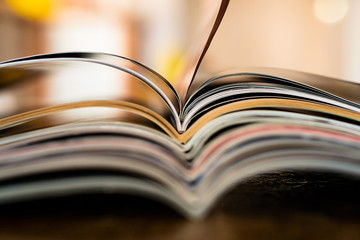 Closeup background of a pile of old magazines with bending pages