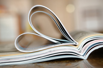Closeup background of a pile of old magazines with bending pages