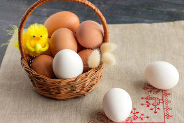 On the table is a wicker basket with eggs, a healthy dietary product. Easter holiday symbol.