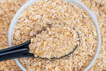 A bowl of whole oats isolated, closeup top view