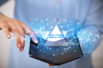 Businessman holding a foldable smartphone with SOLUTION inscription, business concept