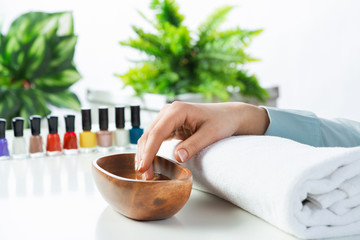 Closeup female hands in wooden bowl with water